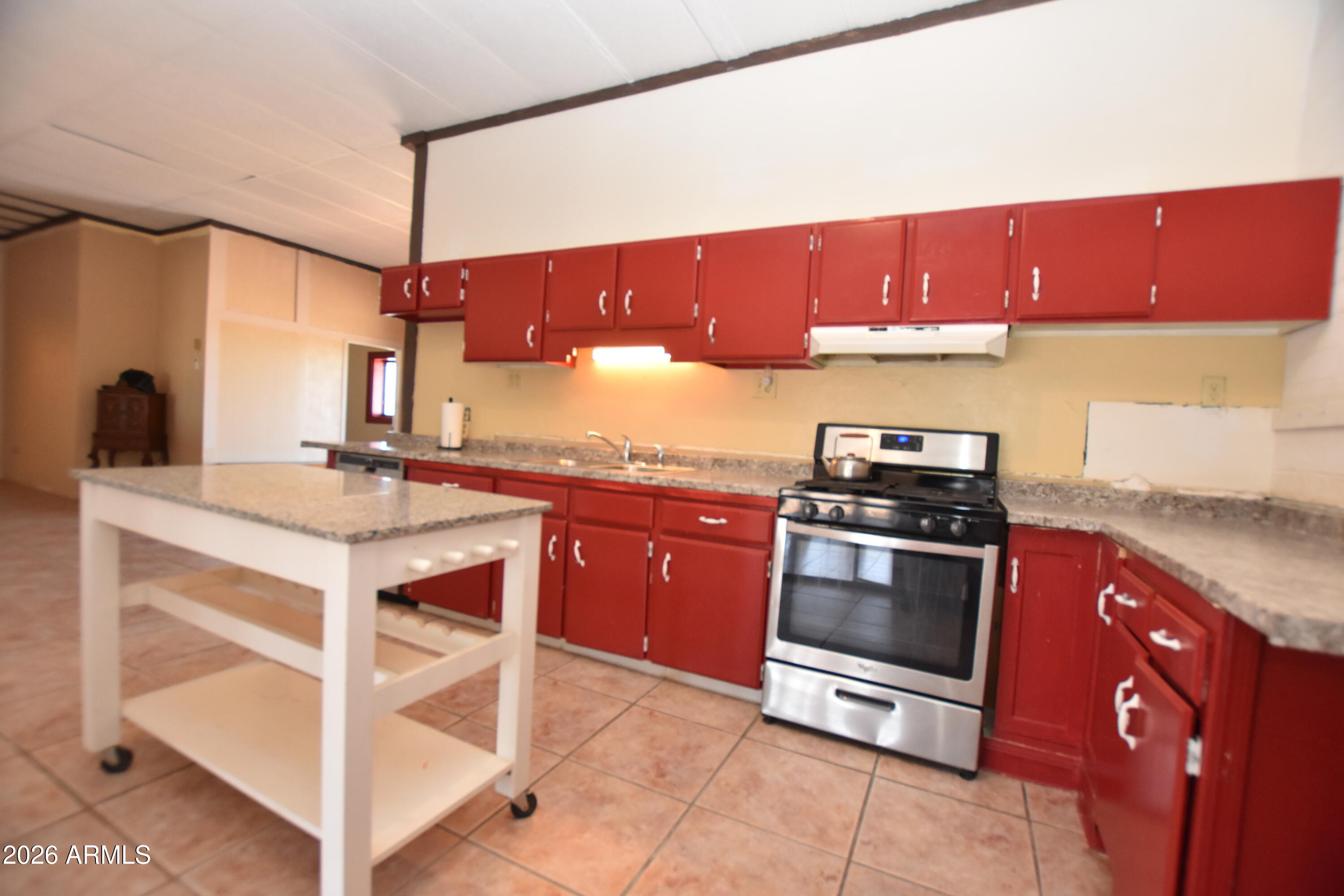 1140 West Briggs Road Ajo, AZ 85321 - Photo 11 of 42 a kitchen with stainless steel appliances kitchen island granite countertop a sink counter space and cabinets