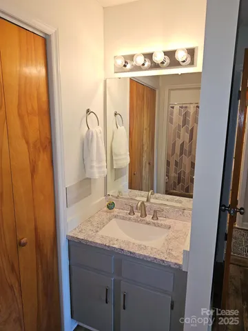a bathroom with a granite countertop sink and a mirror