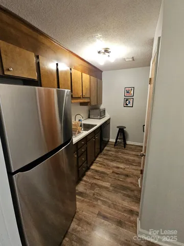 a view of a refrigerator in kitchen and wooden floor