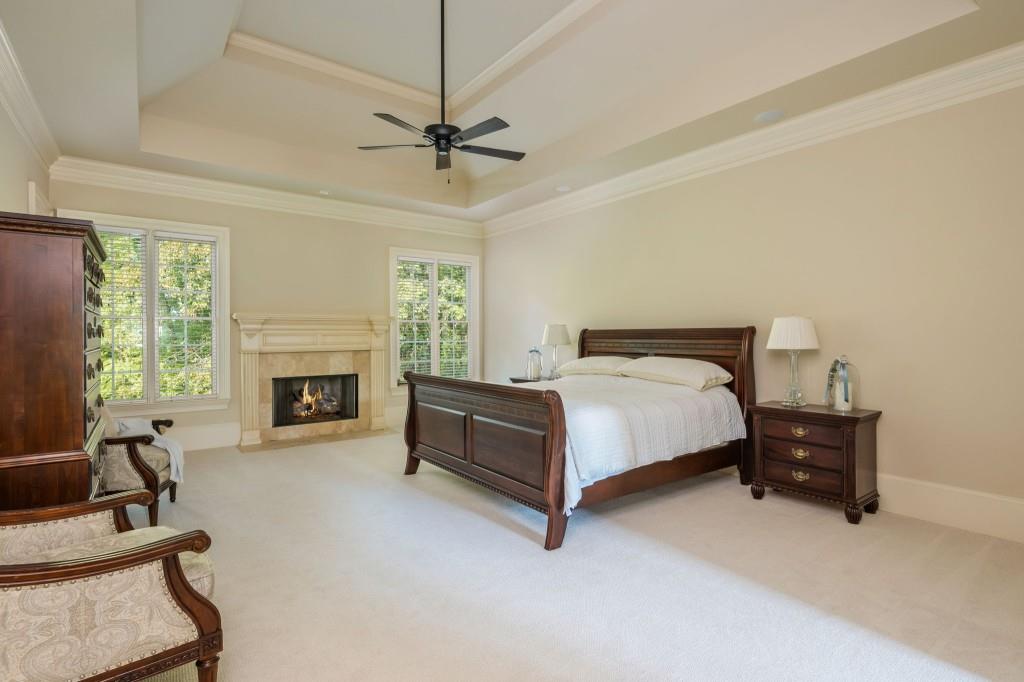 220 Edwards Brook Court Canton, GA 30115 - Photo 35 of 77 a spacious bedroom with a bed and a fireplace