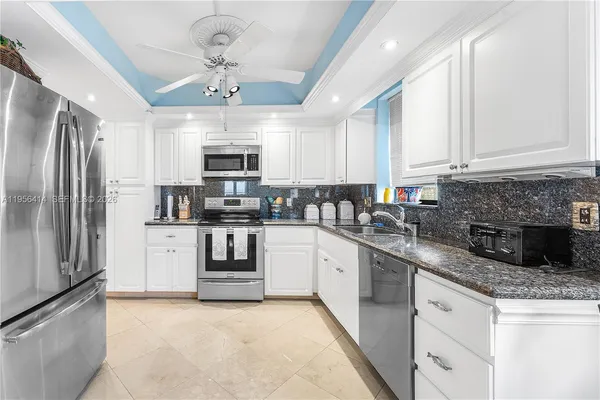 a kitchen with granite countertop a refrigerator oven a sink and dishwasher