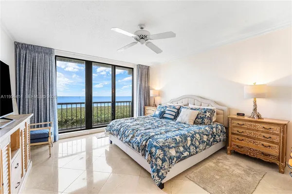 a bedroom with a large bed and a flat tv screen on dresser