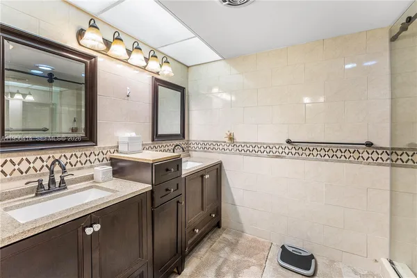 a bathroom with a double vanity sink mirror and
