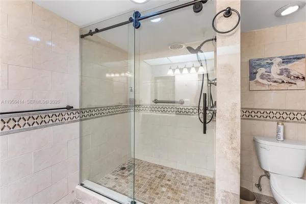 a bathroom with a glass shower door and a shower
