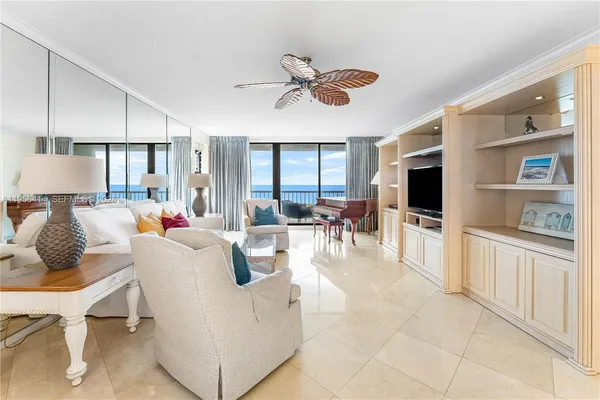a living room with furniture kitchen view and a large window