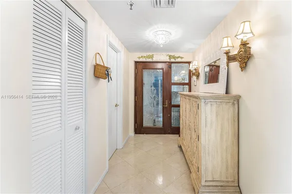a view of a hallway with chandelier and entryway