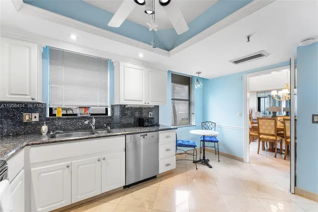 a kitchen with stainless steel appliances granite countertop a sink a stove a refrigerator cabinets and a dining table