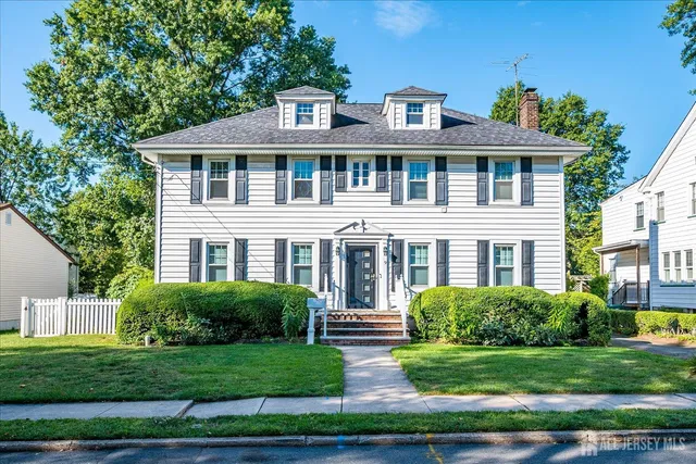 a front view of a house with a yard and potted plants