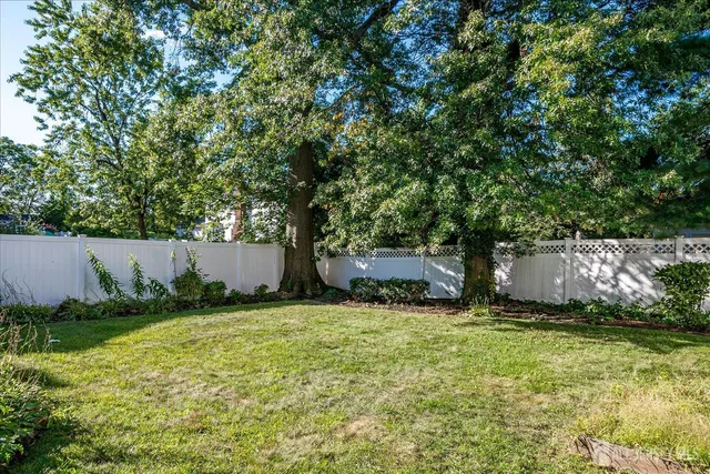 a backyard of a house with table and chairs under an umbrella