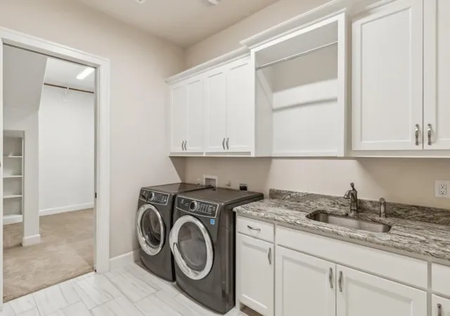 a utility room with sink dryer and washer