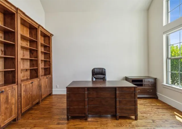 a view of a workspace with furniture and a window