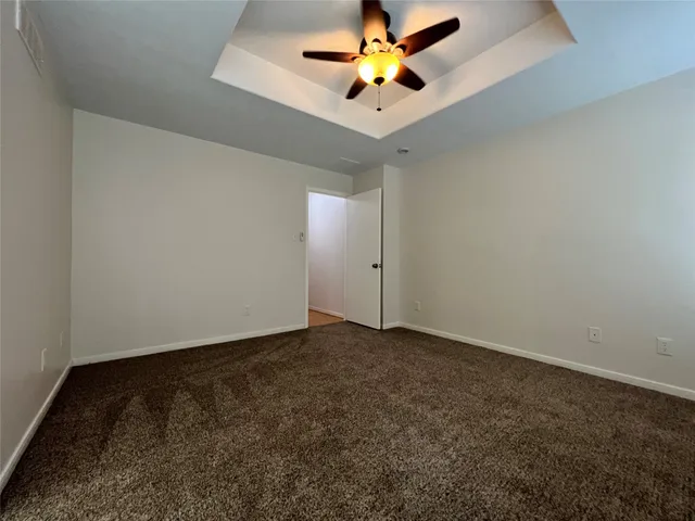 an empty room with a window and a ceiling fan