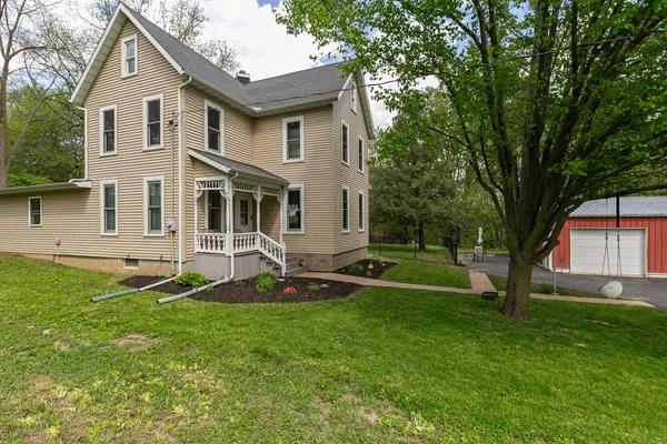 a front view of a house with a yard and trees