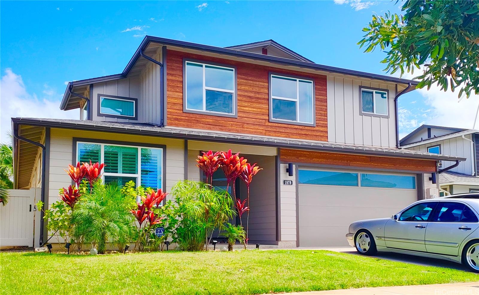 a front view of a house with plants and entryway