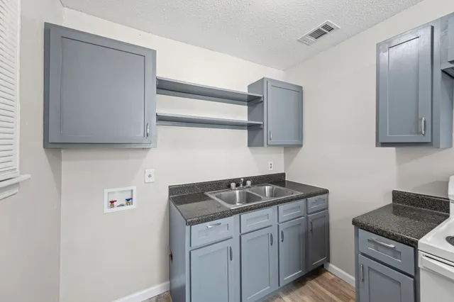 a kitchen with stainless steel appliances granite countertop a sink stove and cabinets