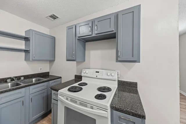 a white stove top oven sitting inside of a kitchen