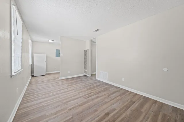 a view of an empty room with wooden floor