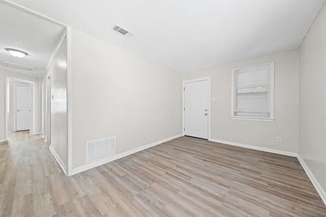 a view of an empty room with wooden floor