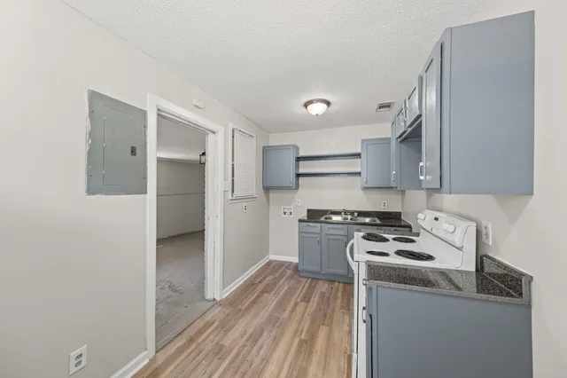 a kitchen with stainless steel appliances a refrigerator a stove and wooden floor