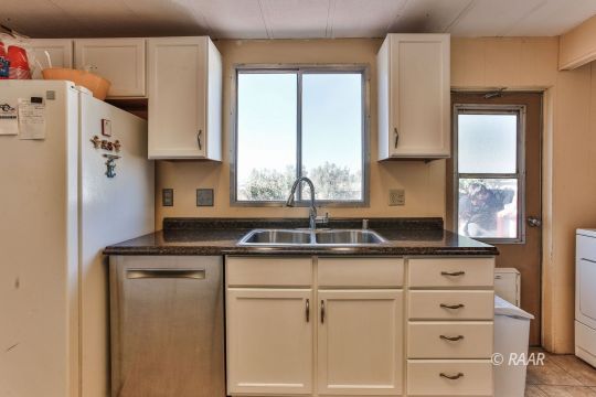 4512 Stark Street Ridgecrest, CA 93555 - Photo 7 of 22 a kitchen with granite countertop a sink cabinets and stainless steel appliances