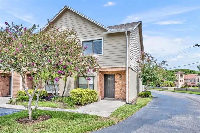 a front view of a house with a yard and potted plants