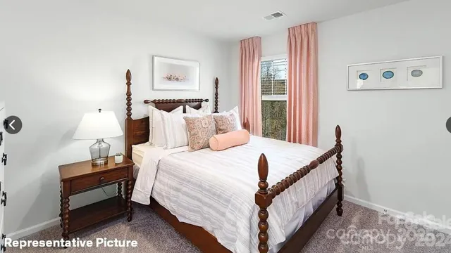 a bed sitting in a bedroom next to a window