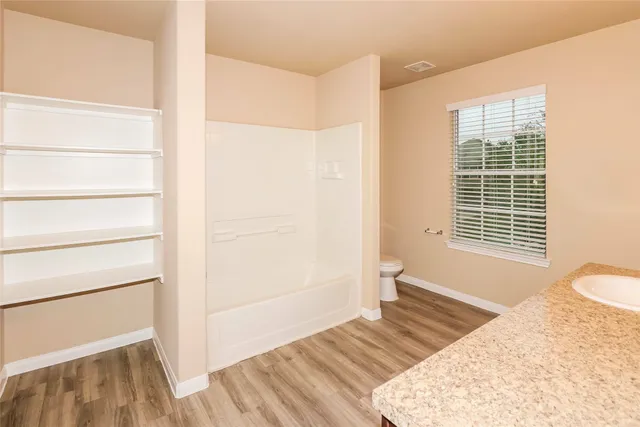 a view of a bedroom with wooden floor and furniture
