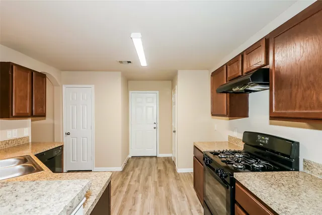 a kitchen with granite countertop a stove and a sink