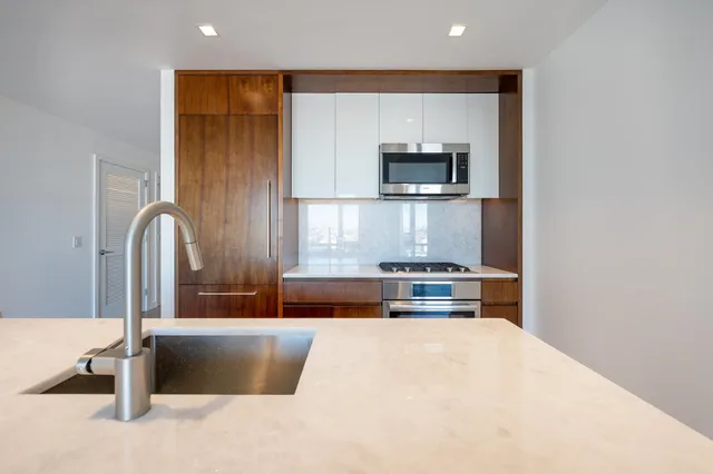 a kitchen with stainless steel appliances granite countertop a sink and a stove top oven