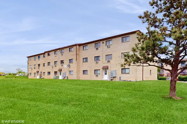 a large white building with a big yard and large trees