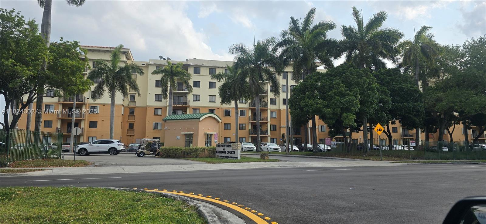 a view of a tall white building next to a road