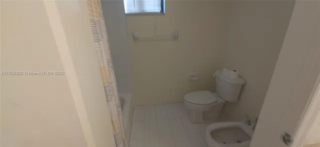 a white toilet sitting next to a shower