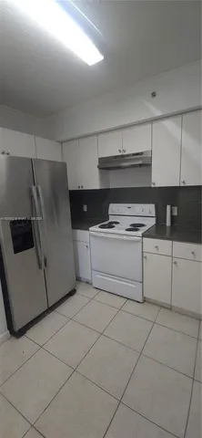 a kitchen with a stove a sink and a refrigerator