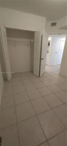 a view of a livingroom with an empty space and a refrigerator