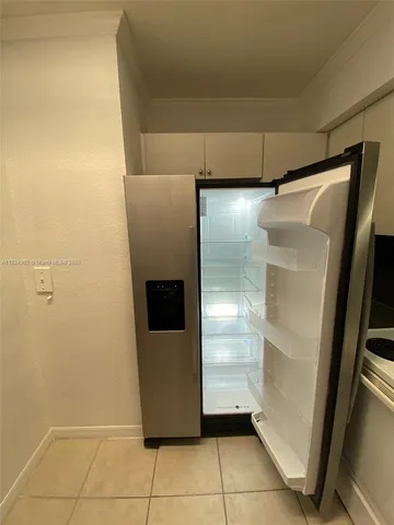 a view of a refrigerator in kitchen and cabinets