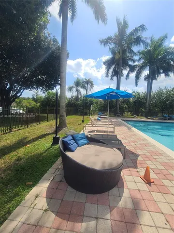 a view of backyard with swimming pool and seating space