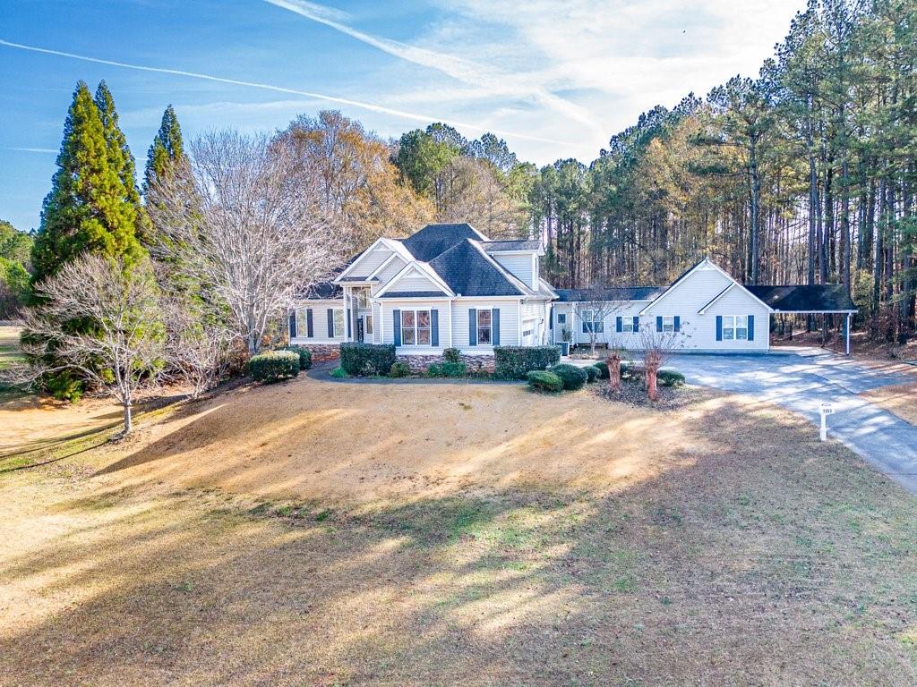 1353 Villa Rica Road Powder Springs, GA 30127 - Photo 1 of 1 a view of a white house with a big yard and large trees
