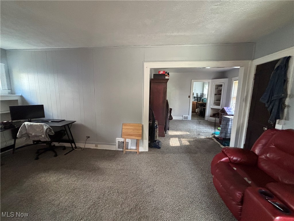 417 Arbor Road Cleveland, OH 44108 - Photo 12 of 20 Living area featuring a textured ceiling, an office area, carpet, and wooden walls