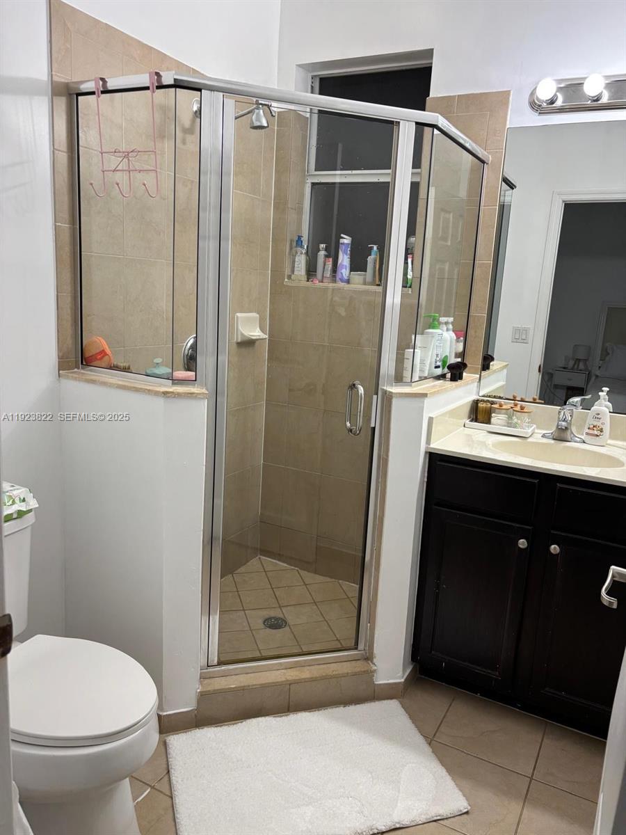 9401 Southwest 172nd Avenue, Unit STUDIO Miami, FL 33196 - Photo 12 of 12 a bathroom with a sink a mirror a toilet and shower