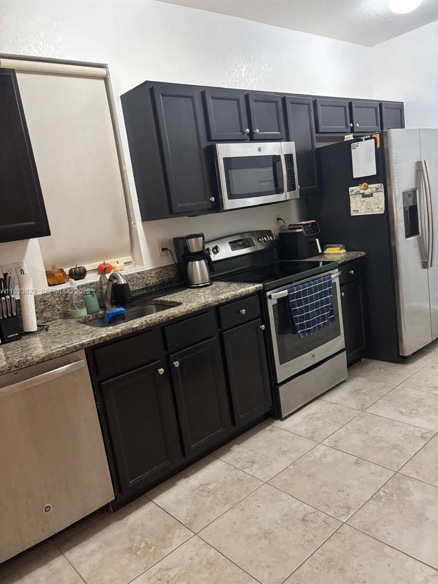 9401 Southwest 172nd Avenue, Unit STUDIO Miami, FL 33196 - Photo 3 of 12 a kitchen with a sink appliances and cabinets