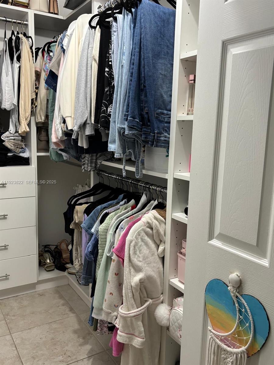 9401 Southwest 172nd Avenue, Unit STUDIO Miami, FL 33196 - Photo 4 of 12 a view of walk in closet with clothes and shoes