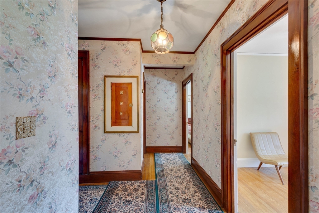 83 Bartlett Avenue Arlington, MA 02476 - Photo 14 of 22 a view of a hallway with wooden floor and a chandelier