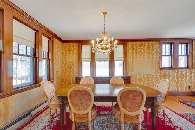 a dining room with chandelier fan and wooden floor