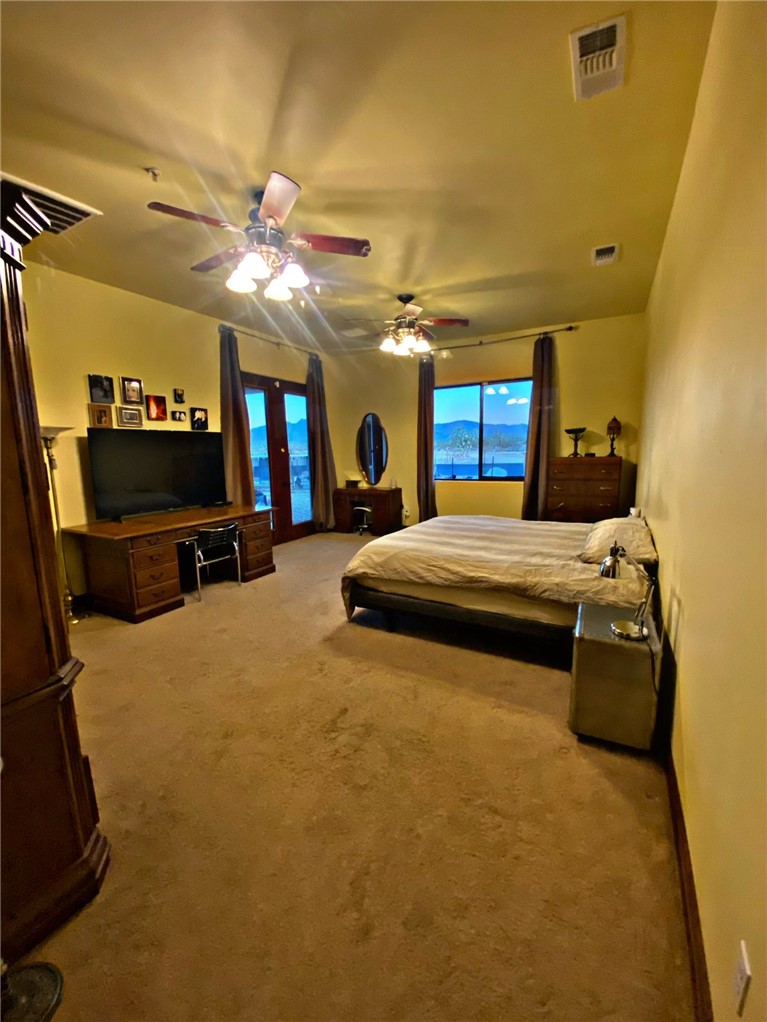 21038 South Cheyenne Road Yucca, AZ 86438 - Photo 35 of 98 Bedroom featuring light carpet and ceiling fan