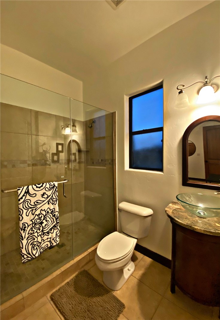 21038 South Cheyenne Road Yucca, AZ 86438 - Photo 48 of 98 Bathroom with light tile flooring, a shower with shower door, mirror, and vanity