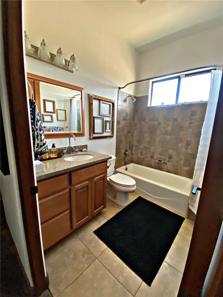 21038 South Cheyenne Road Yucca, AZ 86438 - Photo 53 of 98 Full bathroom featuring mirror, shower / bathtub combination with curtain, light tile floors, and vanity