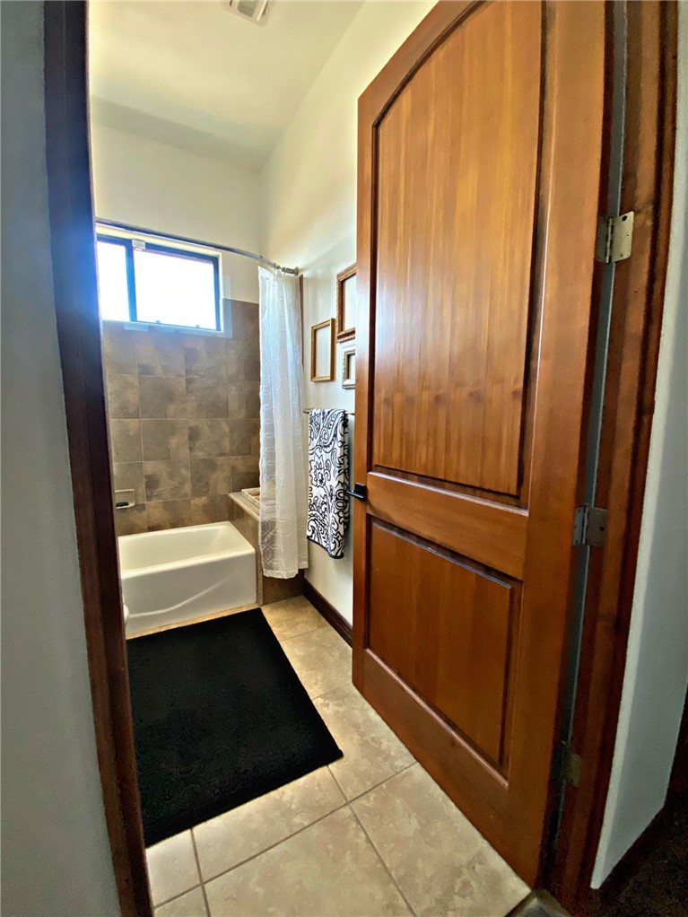 21038 South Cheyenne Road Yucca, AZ 86438 - Photo 54 of 98 Bathroom featuring shower / bath combination with curtain and light tile flooring