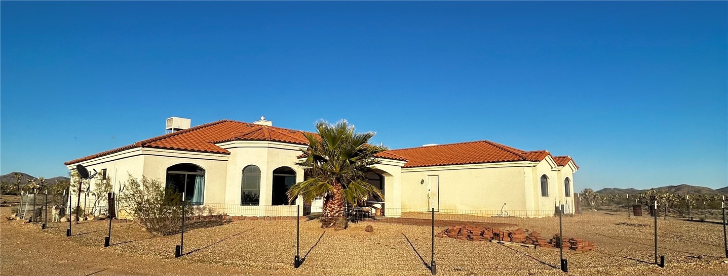 21038 South Cheyenne Road Yucca, AZ 86438 - Photo 6 of 98 Back of house with a tile roof and stucco siding