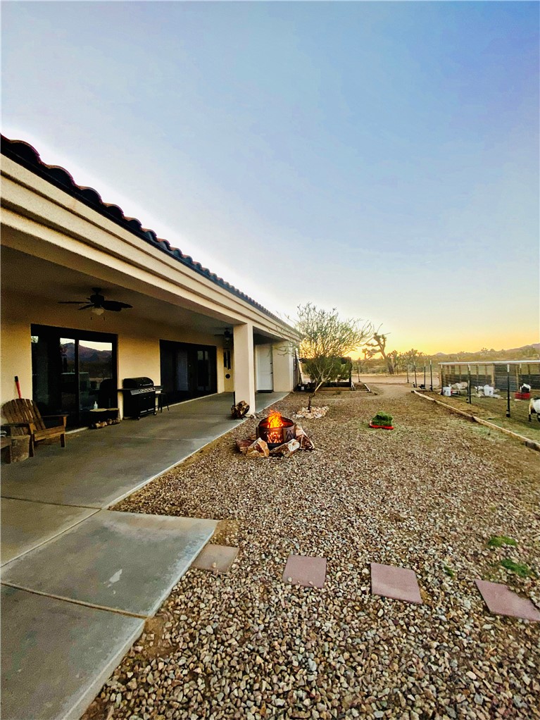 21038 South Cheyenne Road Yucca, AZ 86438 - Photo 70 of 98 Yard at dusk featuring a patio and ceiling fan