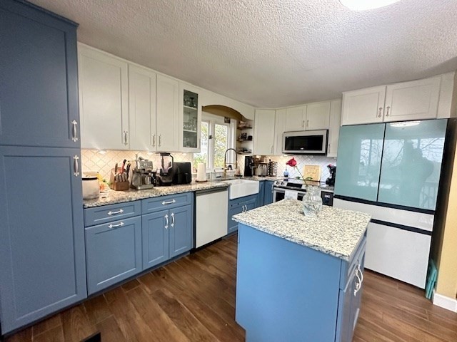 113 Harvard Street, Unit 1 Everett, MA 02149 - Photo 2 of 24 a kitchen with a refrigerator a stove a sink dishwasher and wooden cabinets with wooden floor